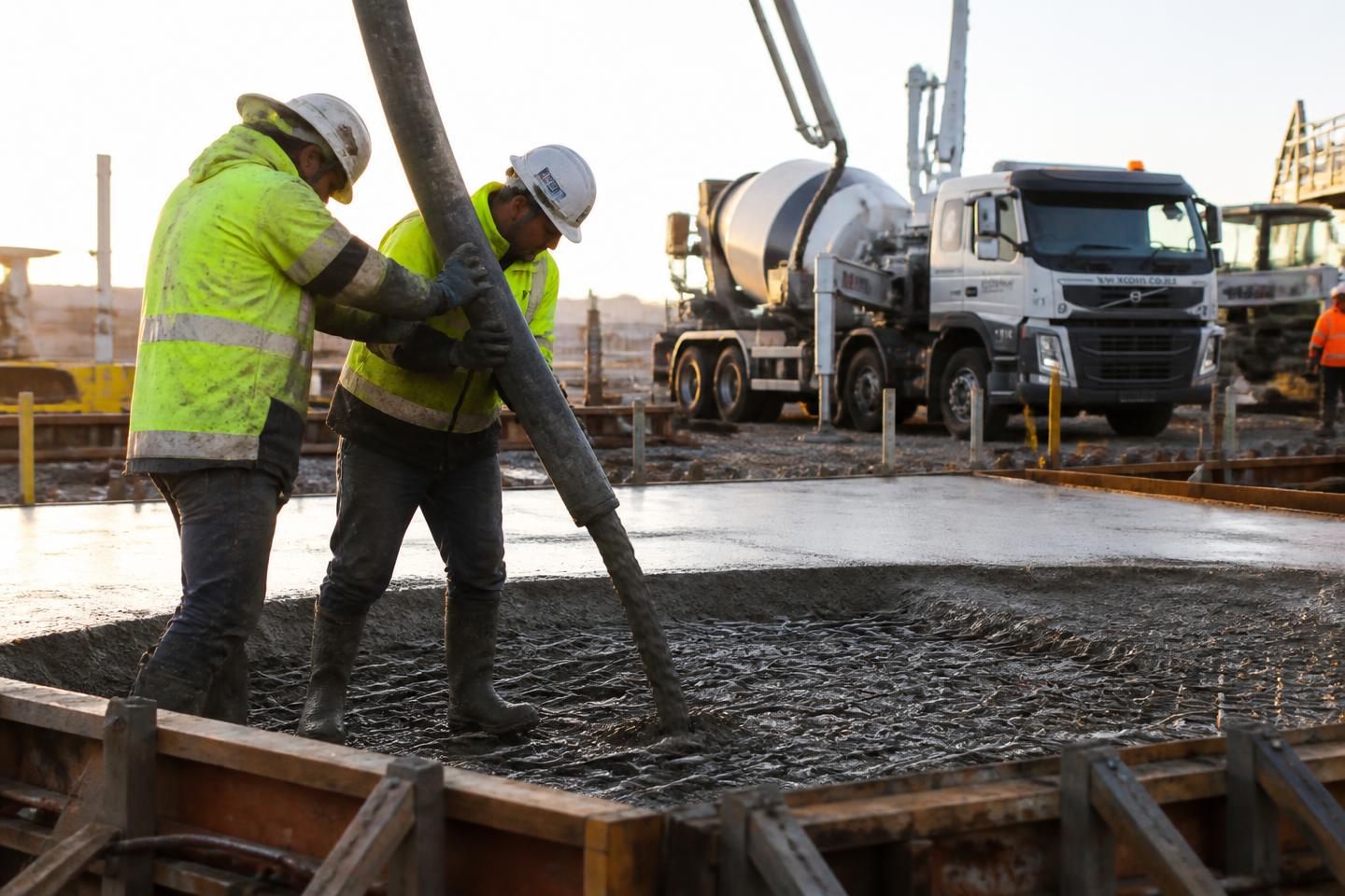 Concrete line pump placing wet cement into a formed slab