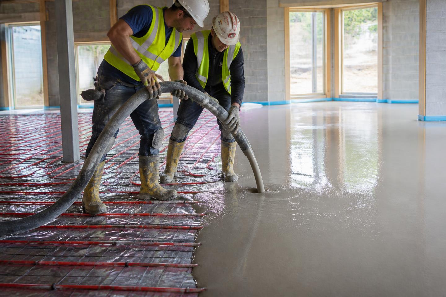 Flowing screed pumped onto a subfloor over underfloor heating pipes